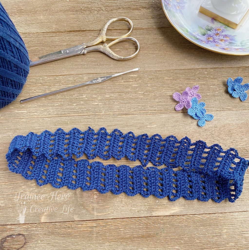 Navy blue crochet headband made from crochet edging pattern.