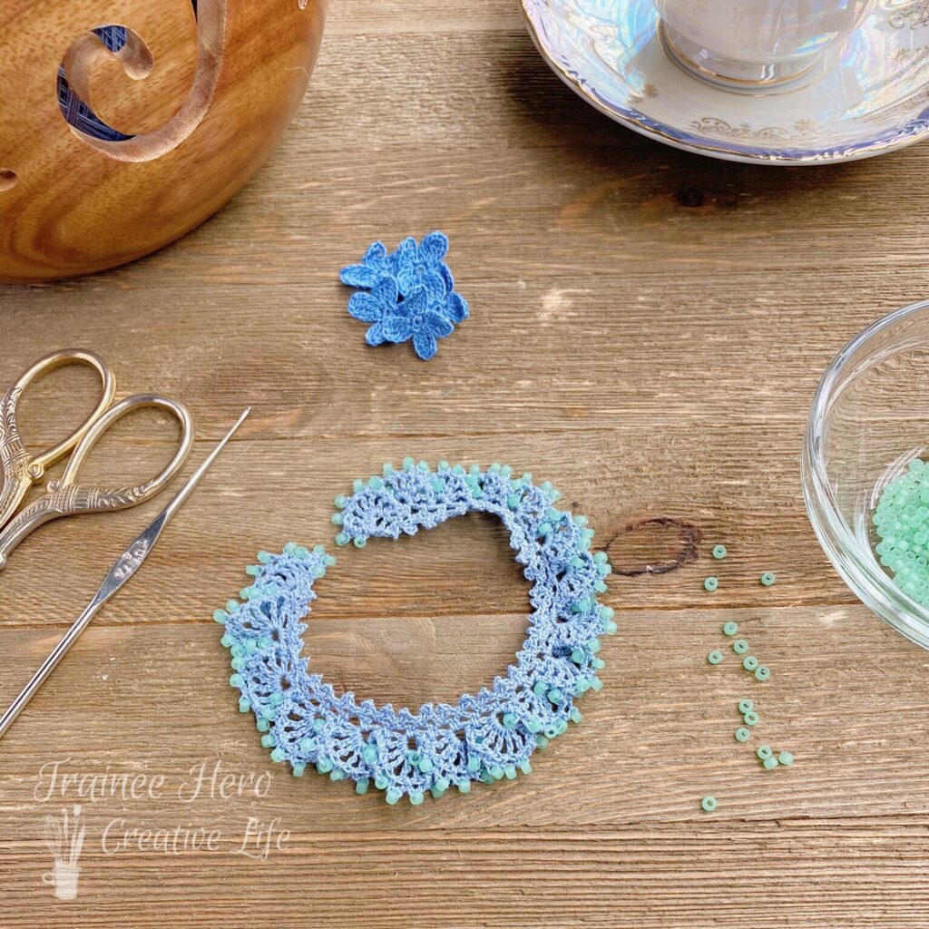 One crocheted bracelet with beads laid out in a circle.