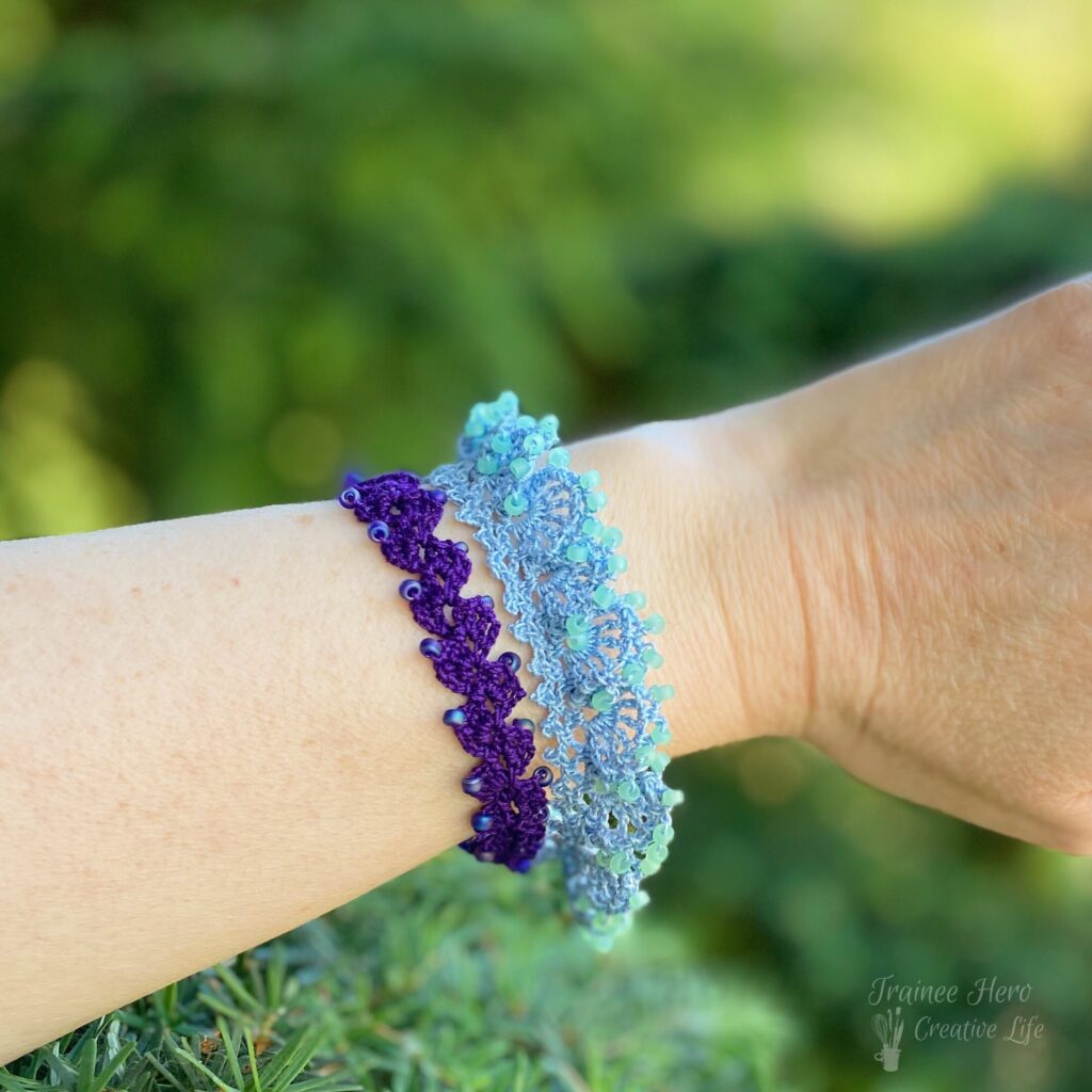 Two crocheted bracelets on a wrist.