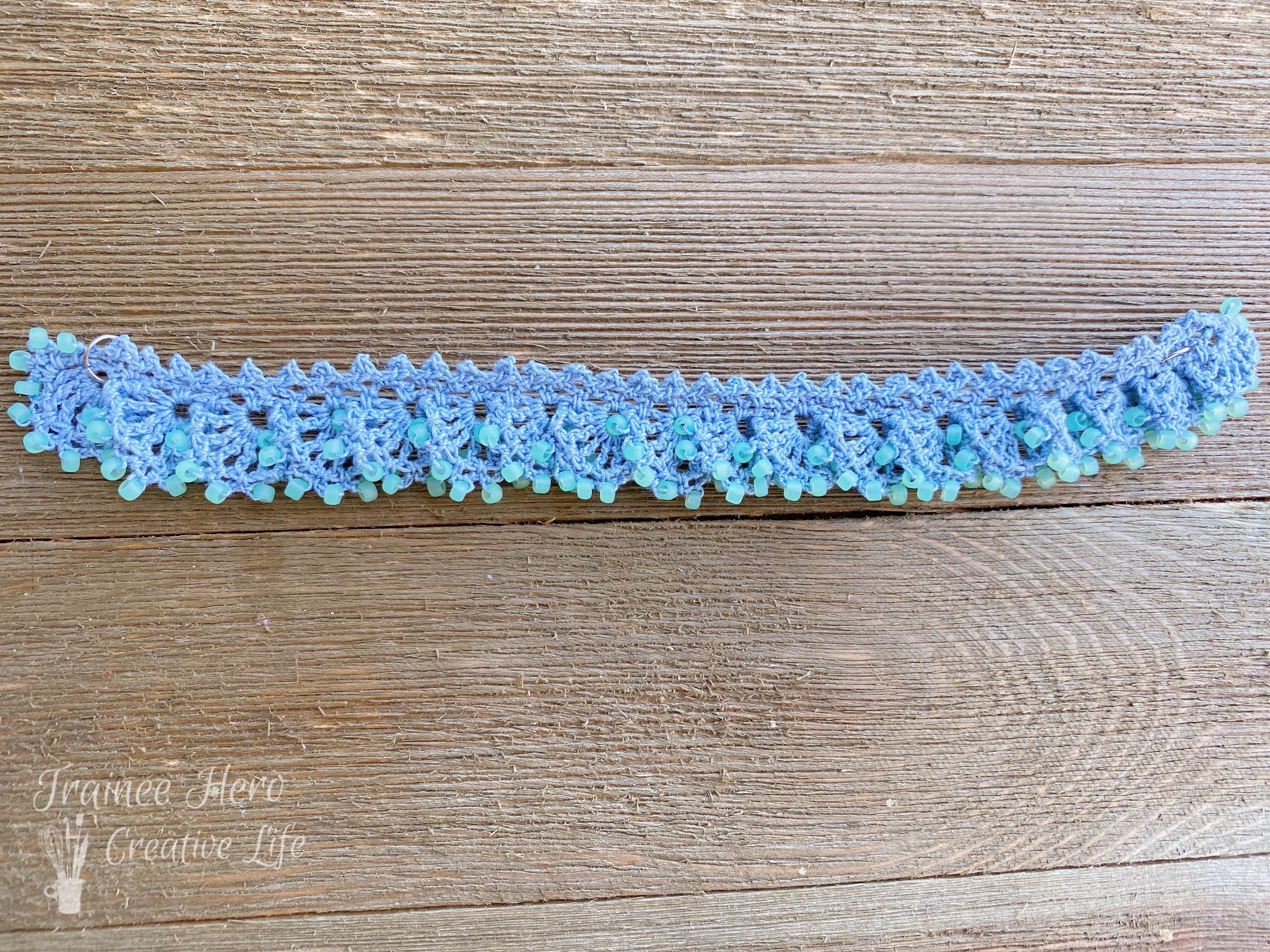 One crochet bracelet with beads laid out flat.