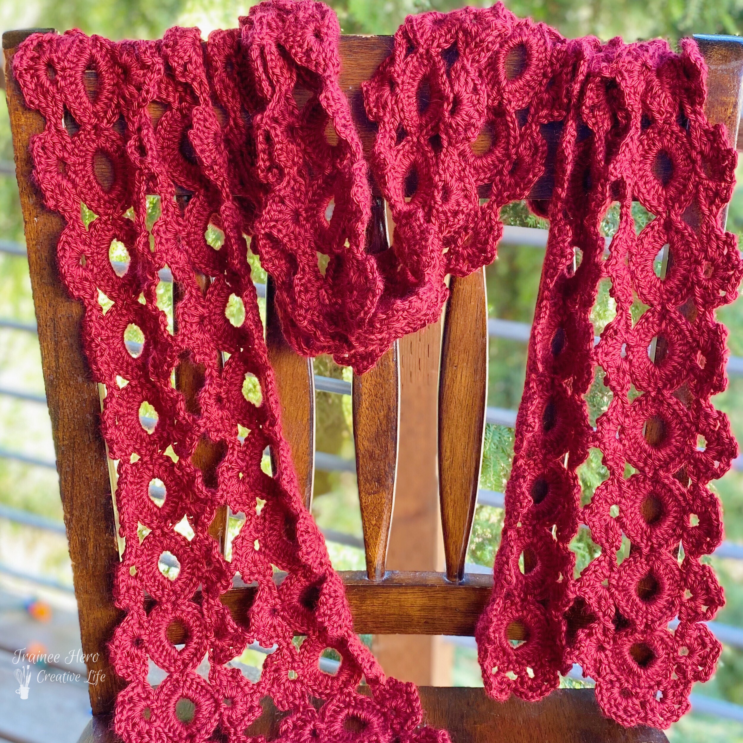 Poppy Fields Scarf, a crocheted scarf, draped over a chair.