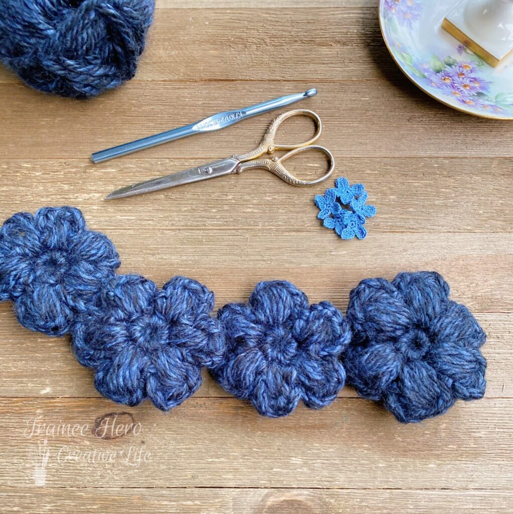 Four chunky crochet puff stitch flowers.