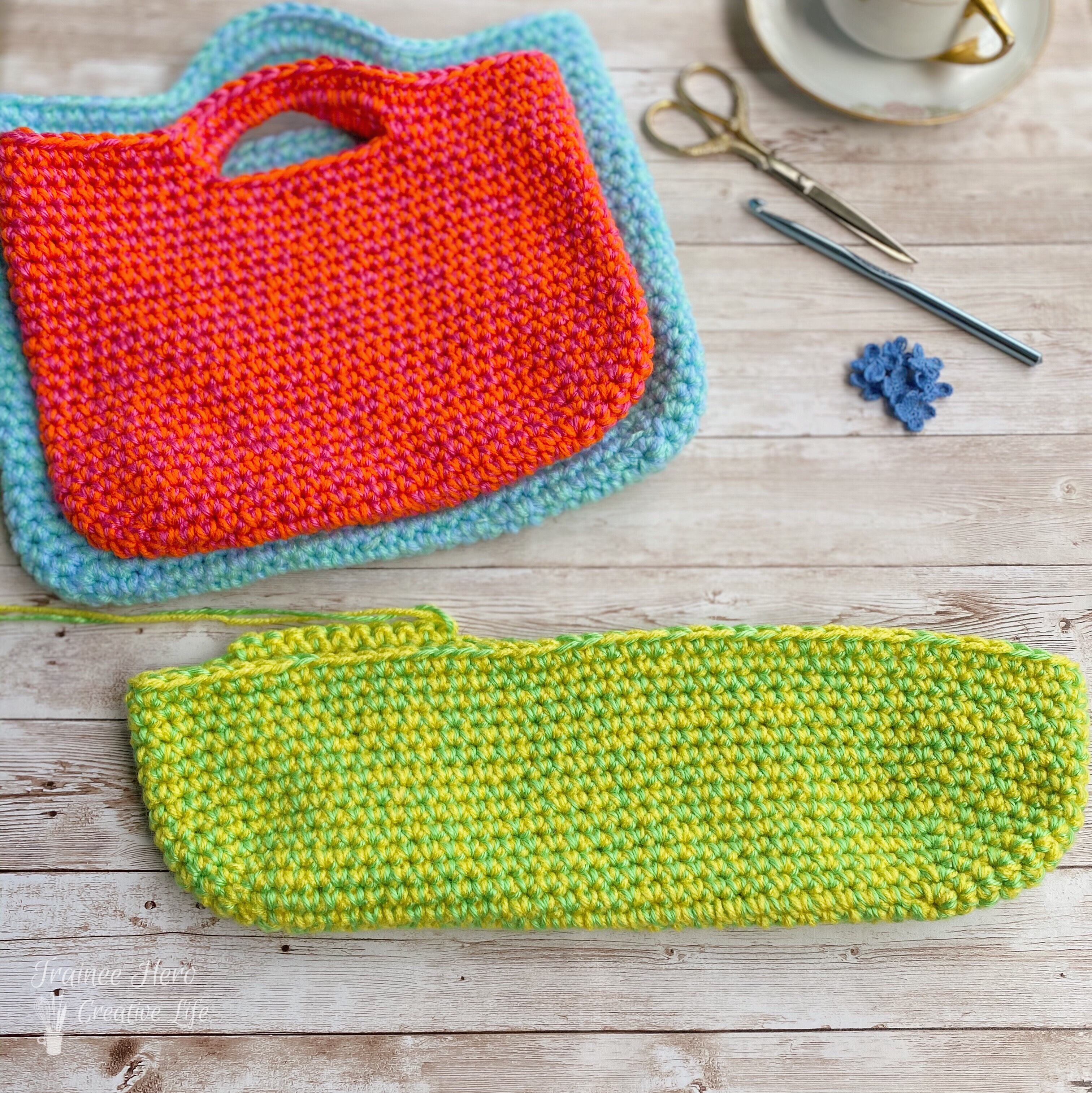 Two finished crocheted bags. One crocheted bag started below it.