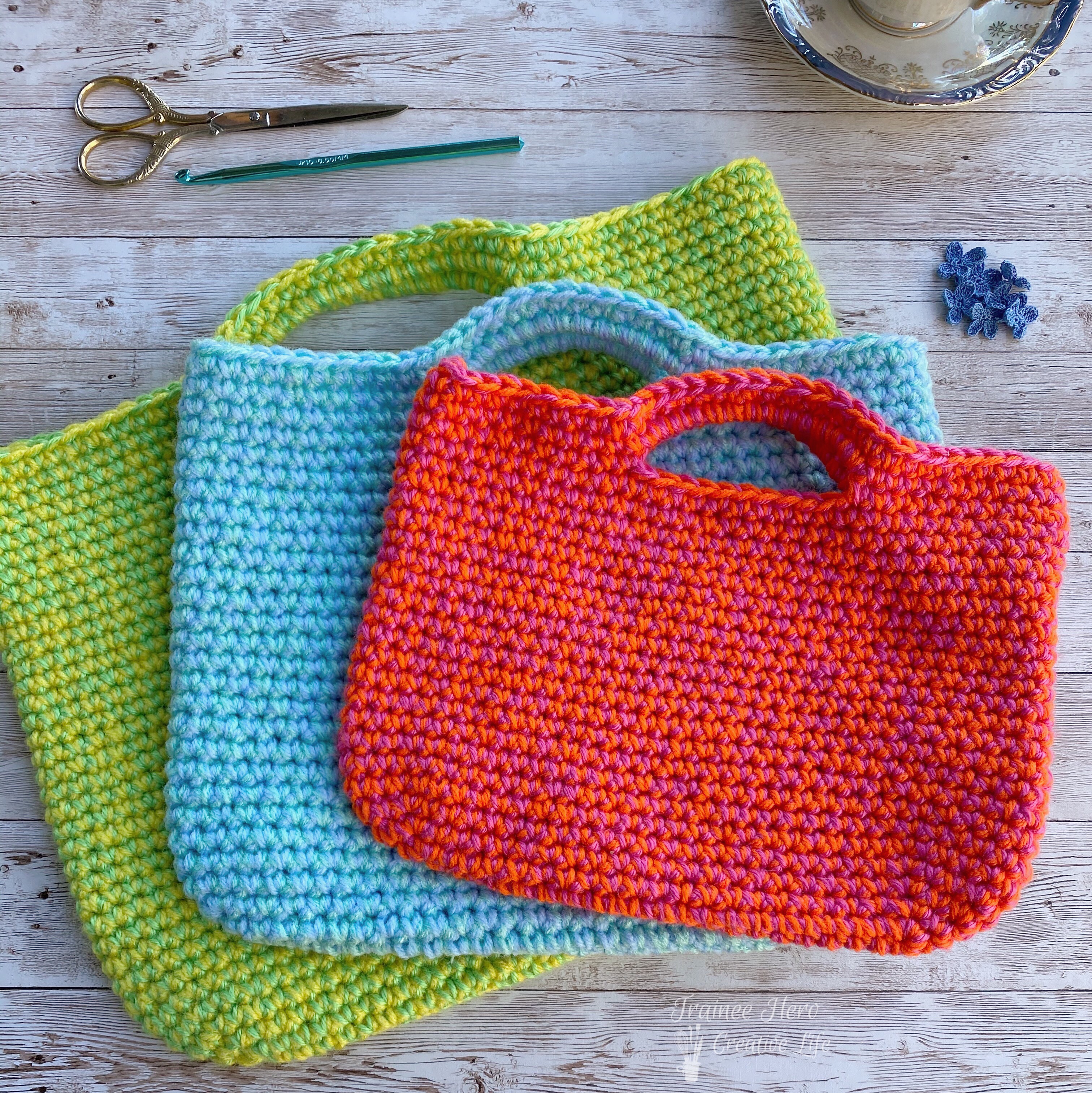 Three crochet project bags in a stack.