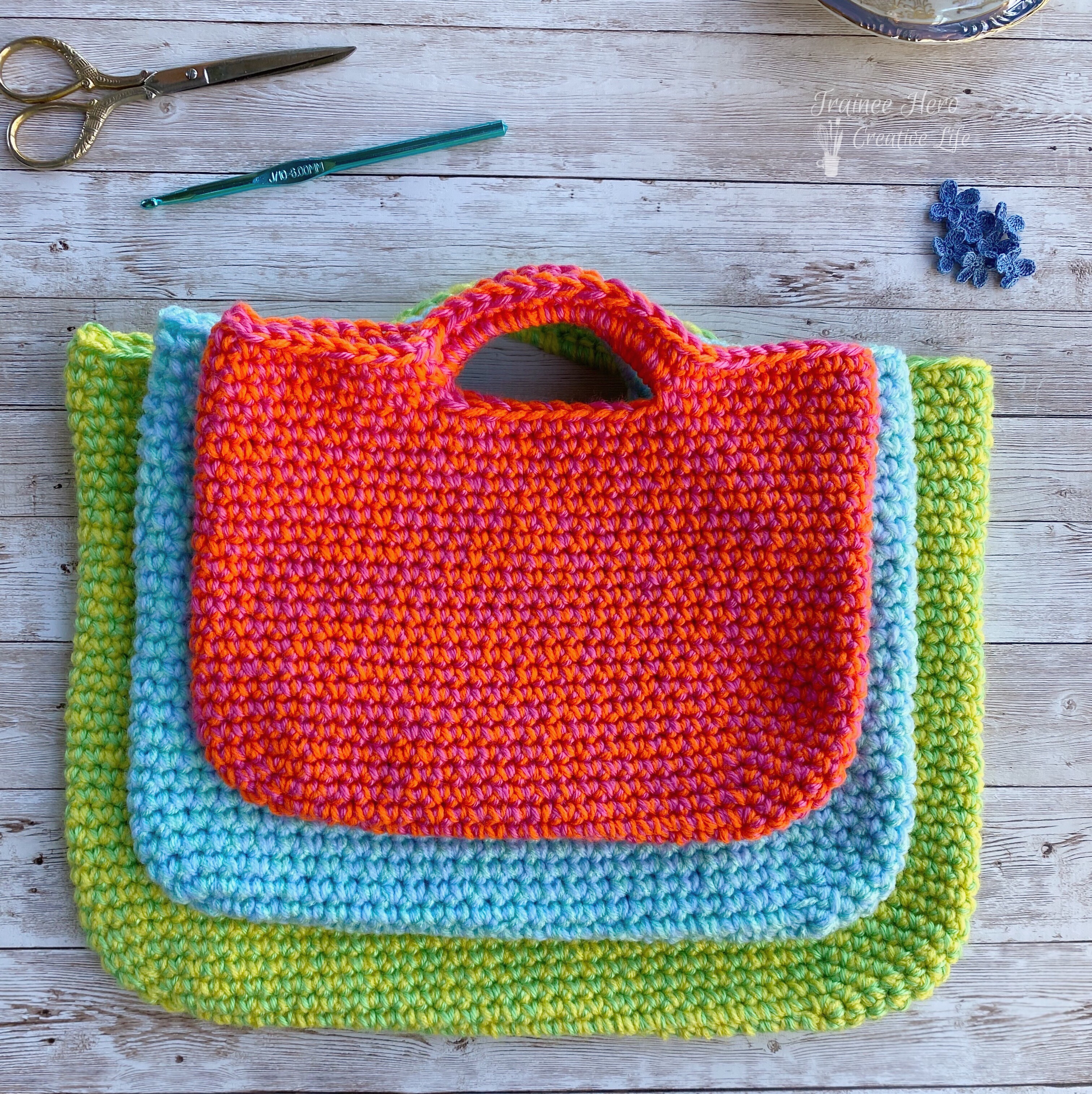 A stack of crochet project bags, the  smallest one on top.