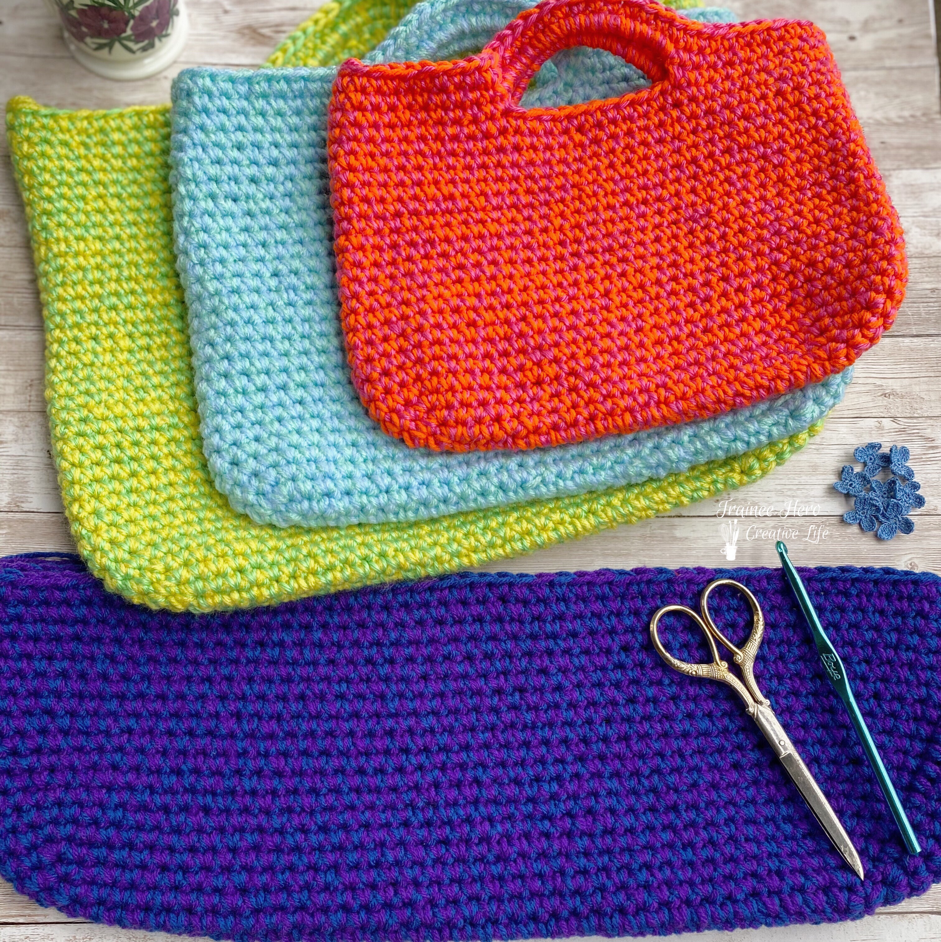 Three finished crocheted bags and one crochet bag in progress.